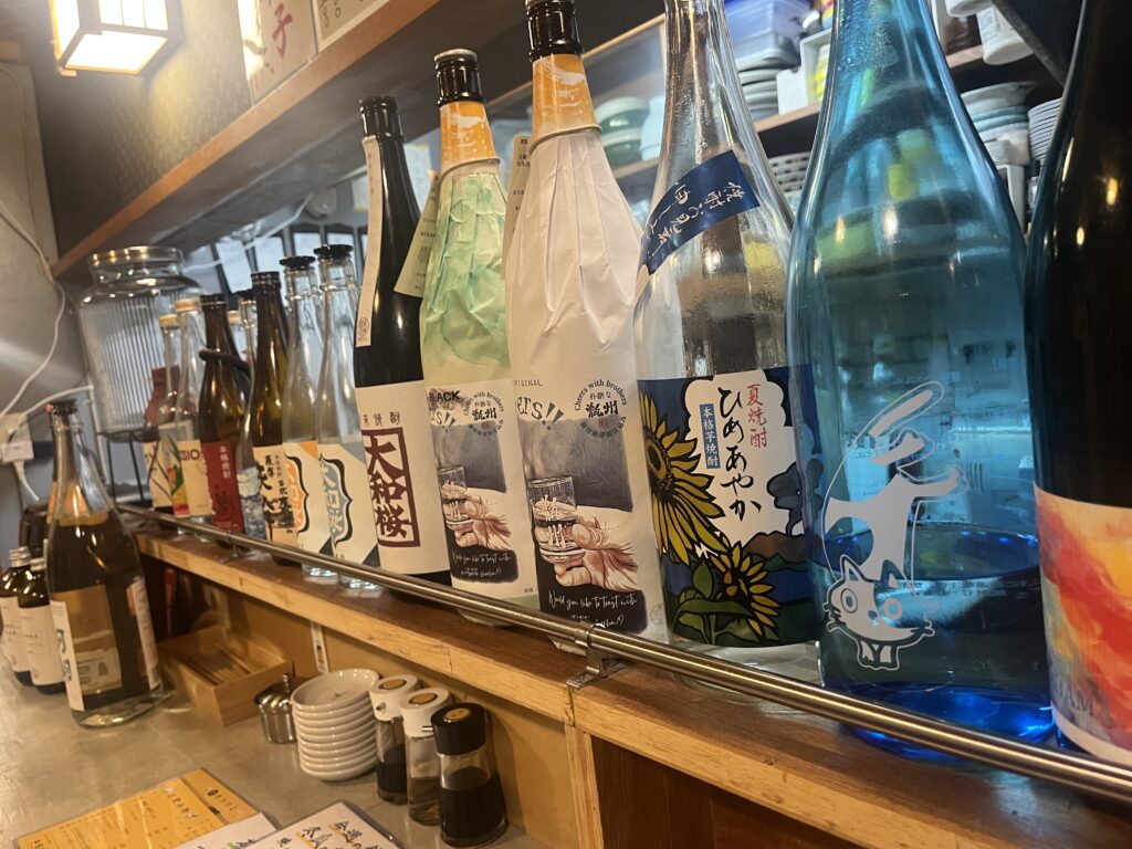 こんぺい餃子のカウンターに並ぶ焼酎と古酒