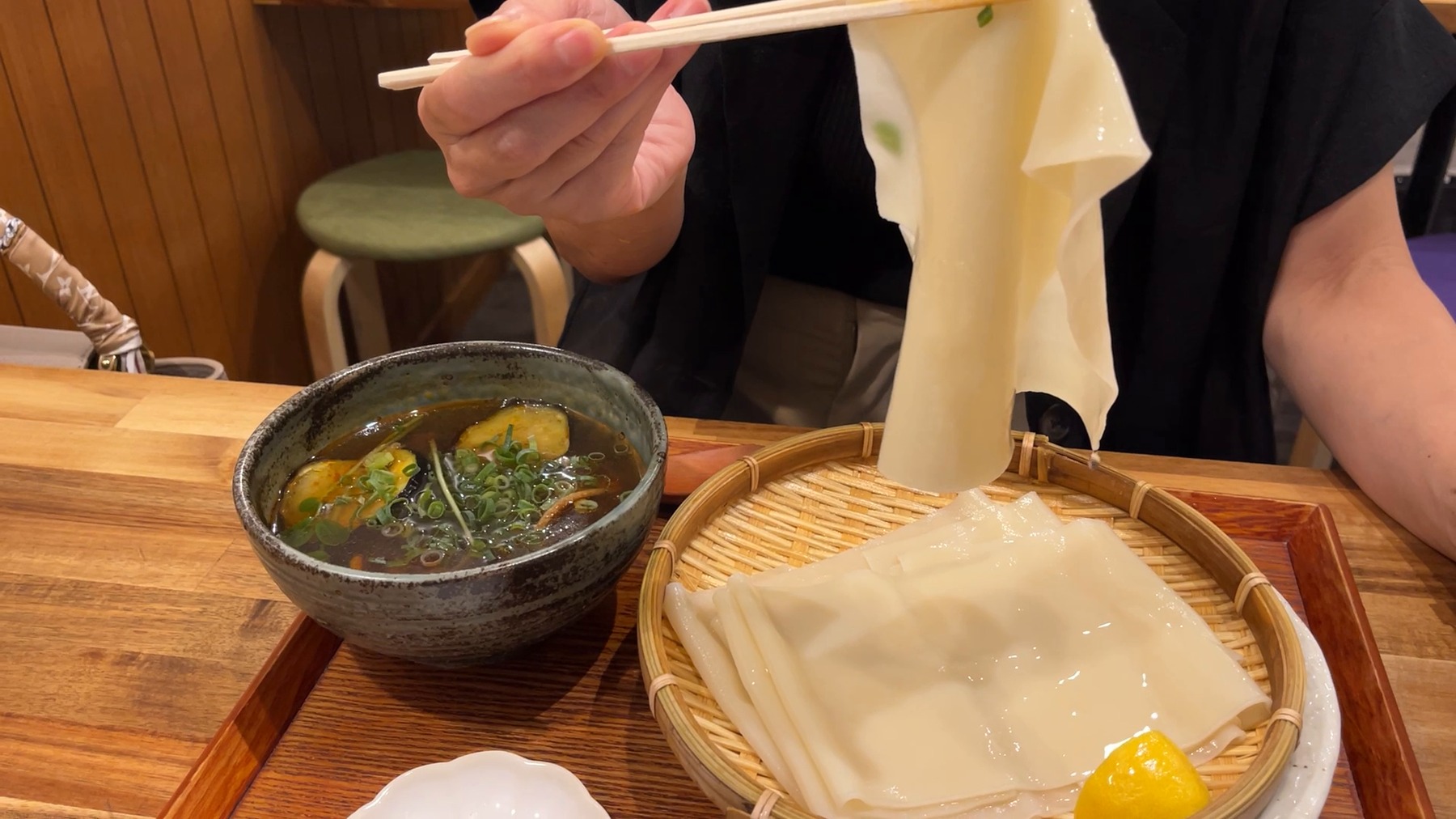 ひもかわ桐生池袋店の超幅広ひもかわうどんを箸で持ち上げた様子