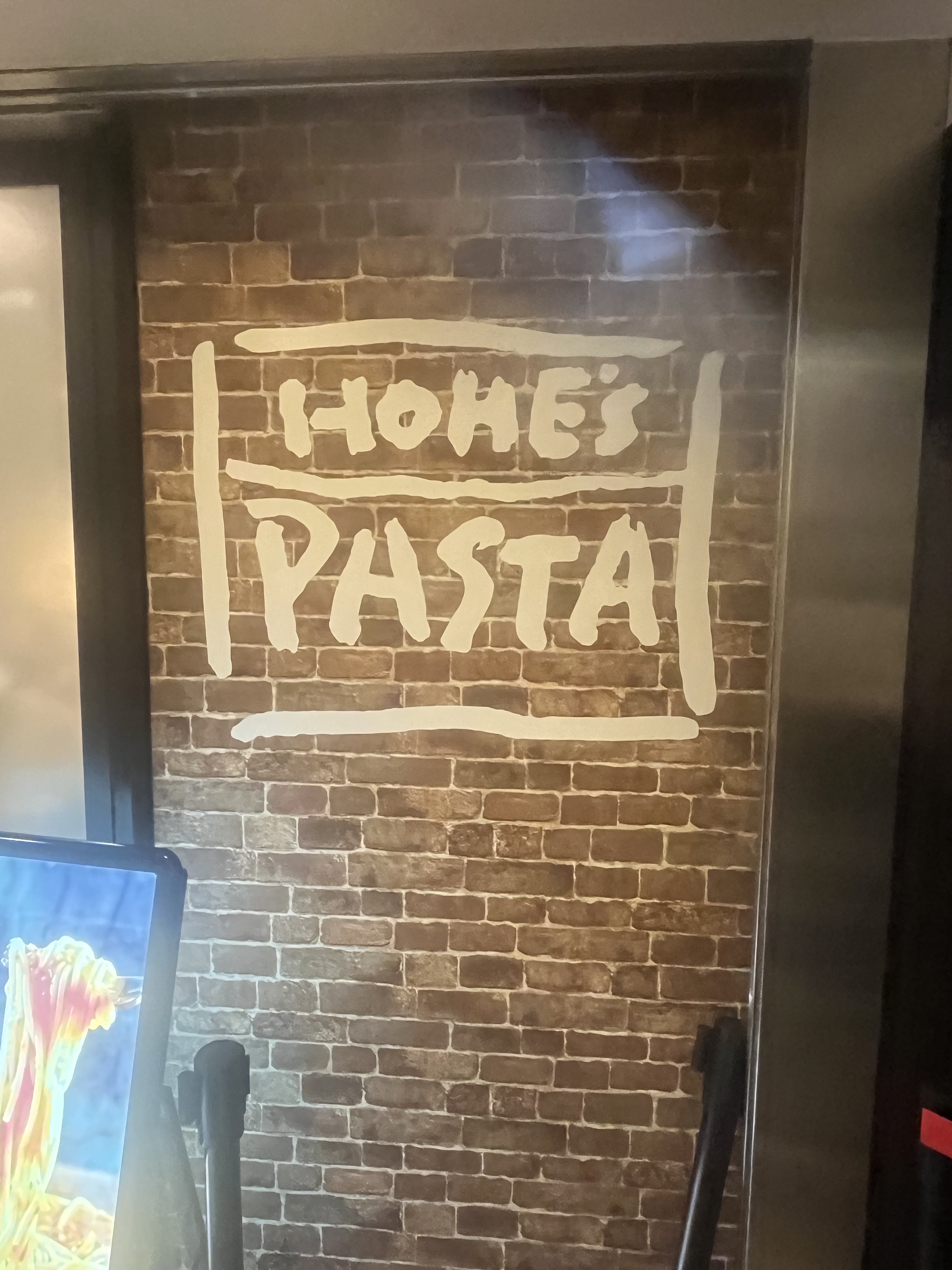 HOME'S PASTAのロゴが描かれたレンガ壁
